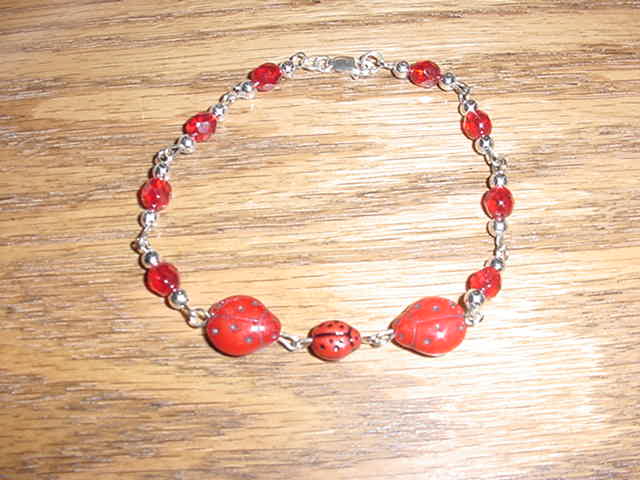 Family ladybug sterling silver bracelet with a lobster claw clasp.